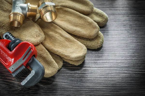 Llave de tubo conectores guantes de seguridad en tablero de madera — Foto de Stock