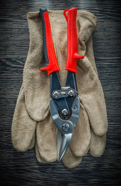 Protective gloves steel cutter on wooden board — Stock Photo, Image