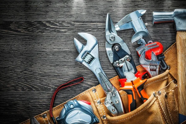 Set of leather tool belt with construction tooling on wooden boa — Stock Photo, Image