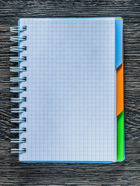 Opened checked notepad on vintage wooden board top view