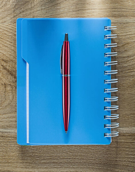 Pen spiral copybook on wooden board