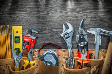 Building belt with construction tools on wooden board clipart