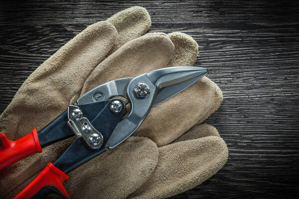 Protective gloves steel scissors on wooden board