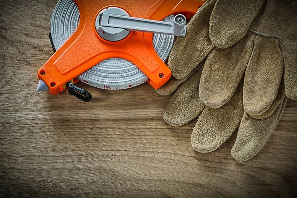 Safety gloves tape measure on wooden board