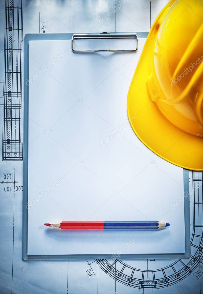 Clipboard pencil building helmet on blueprint construction conce