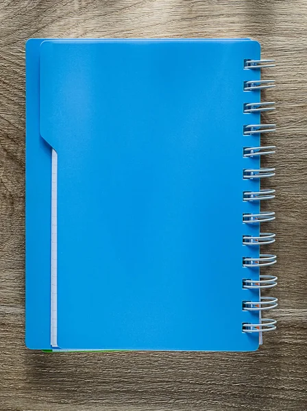 Copybook espiral azul na placa de madeira — Fotografia de Stock