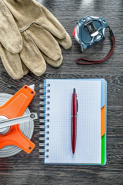 Construction measuring tape safety gloves notebook pen on wooden — Stock Photo, Image