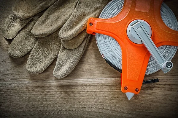 Gants de protection ruban à mesurer sur planche en bois — Photo