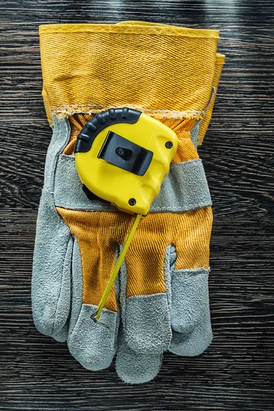 Tape measure protective gloves on wooden board — Stock Photo, Image