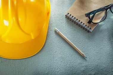 Bina kask gözlük defter kalem beton zemin üzerine