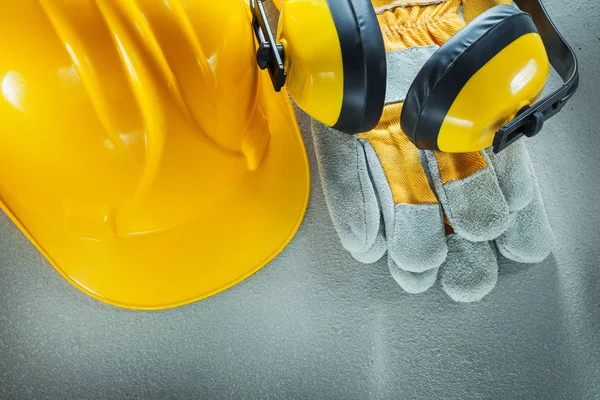 Auriculares luvas de proteção edifício capacete em backgroun concreto — Fotografia de Stock