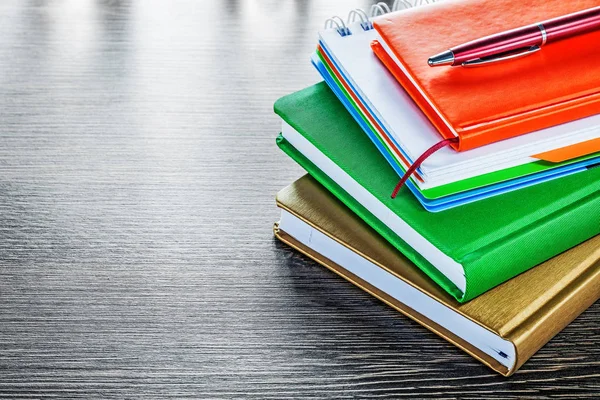 Pile of notebooks pen on wooden board — Stock Photo, Image