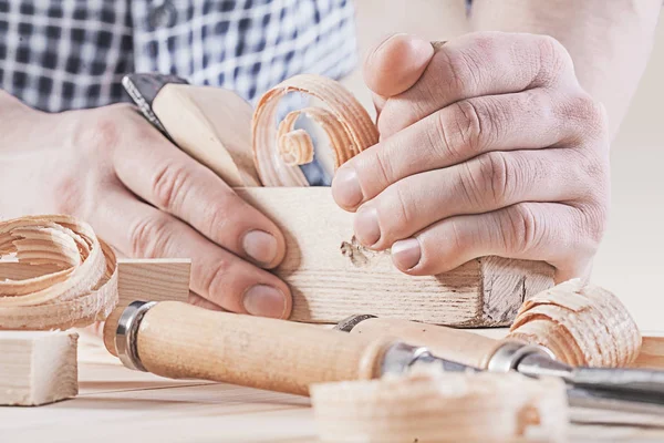 Woodworkers plane in hands of carpenter very close up — Stock Photo, Image