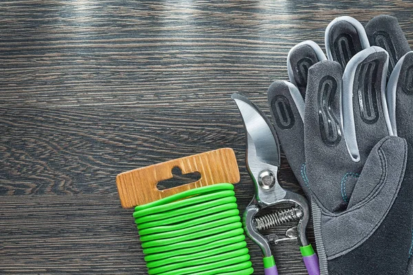 Protective gloves secateurs garden wire on wooden board — Stock Photo, Image