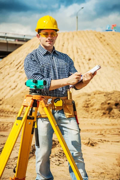Een jonge werknemer met Klembord op bouwplaats — Stockfoto