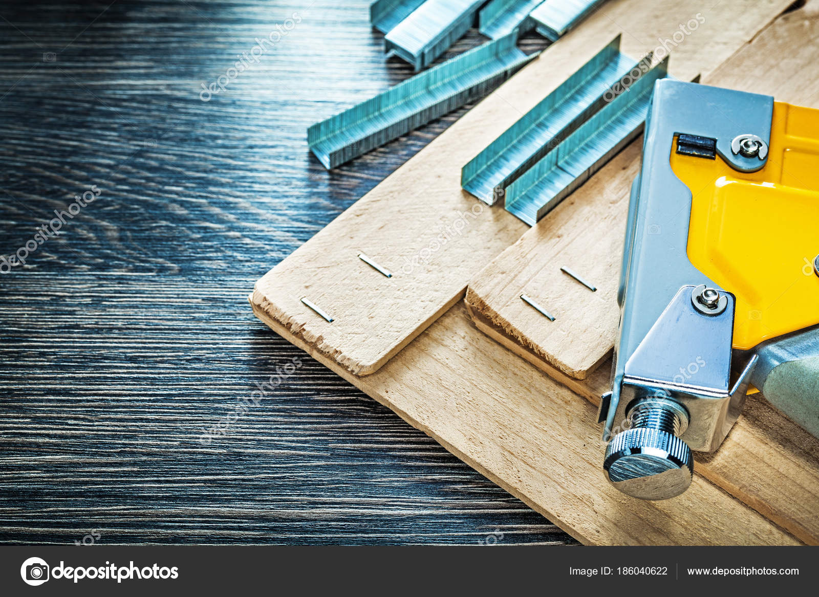 Carpenter Using an Industrial Construction Stapler on a Wood Plank