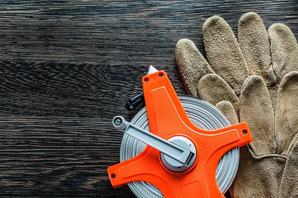 Вимірювальні стрічкові захисні рукавички на дерев'яній дошці — стокове фото
