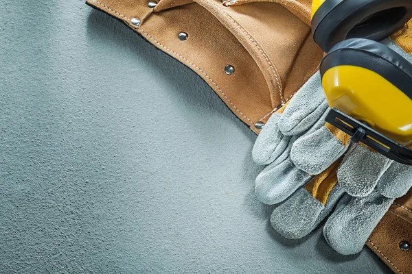 Conjunto de guantes de seguridad cinturón de herramientas de cuero orejeras en la espalda de hormigón — Foto de Stock