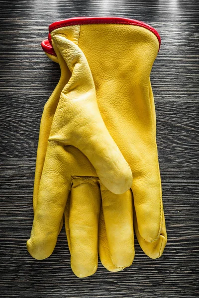 Leather protective gloves on wooden board