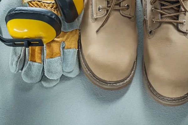 Safety boots gloves earmuffs on concrete background — Stock Photo, Image