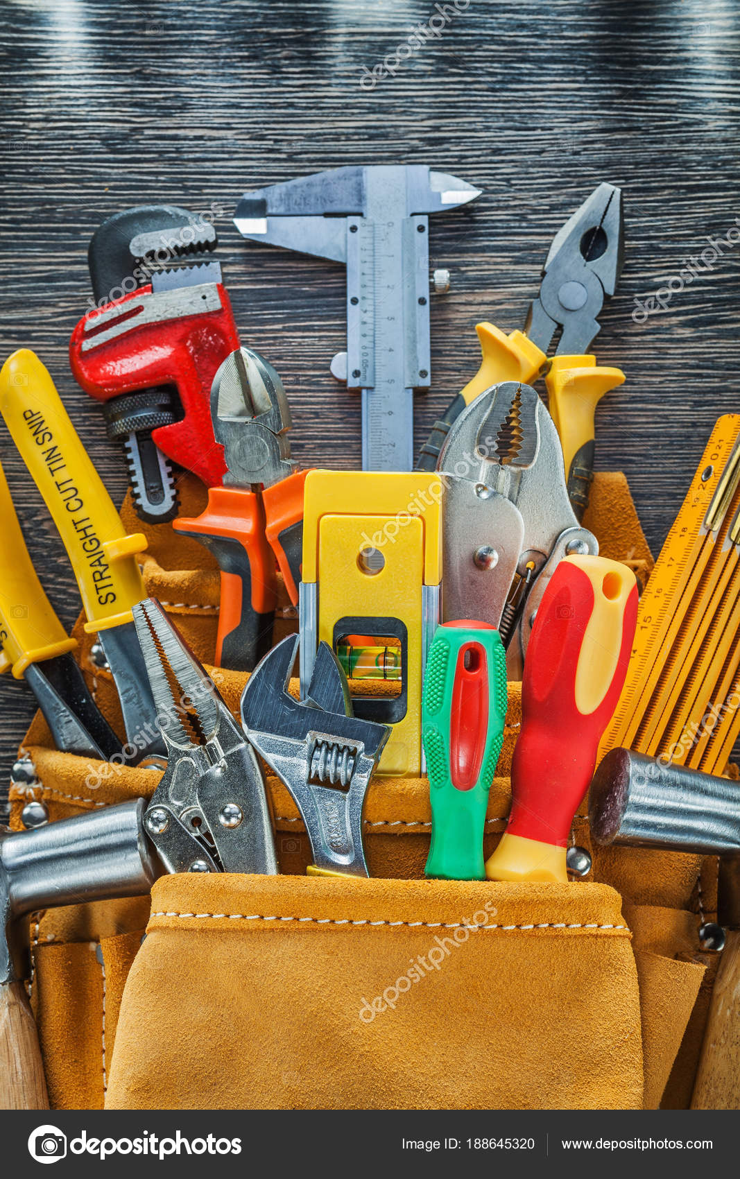 Leather tool belt construction tooling on wooden board directly Stock
