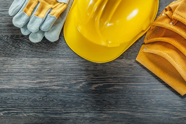 Correa de herramientas de cuero guantes de protección de sombrero duro en tablero de madera —  Fotos de Stock