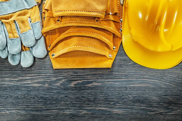 Leder gereedschap riem hard hat veiligheidshandschoenen op houten bord — Stockfoto