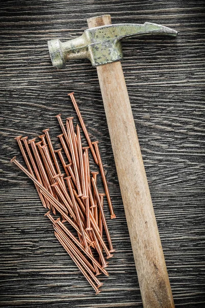 Mucchio di chiodi di ottone artiglio martello su tavola di legno — Foto Stock