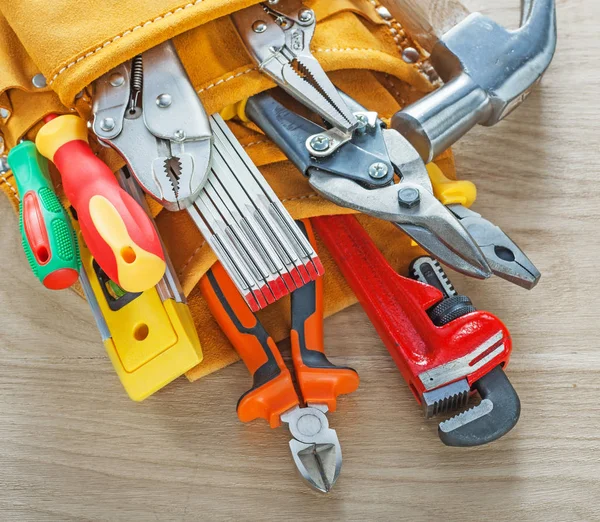 Construction tooling in building belt on wooden board — Stock Photo, Image