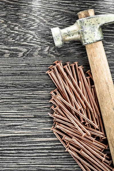 Pilha de pregos de cobre garra martelo na placa de madeira — Fotografia de Stock