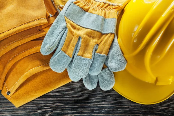 Leather tool belt hard hat pair of safety gloves on wooden board Royalty Free Stock Photos