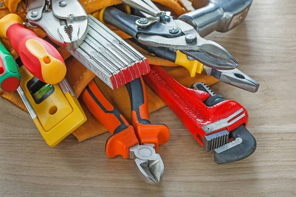 Bouw gereedschap in leder gebouw gordel op houten bord — Stockfoto