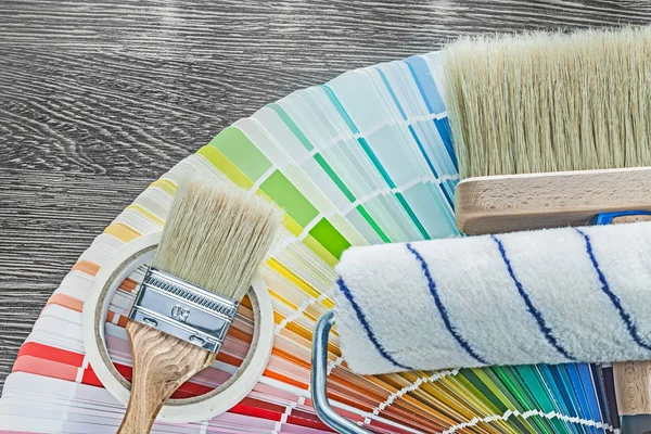 Краска кисти ролик цвета палитры бытовой ленты на деревянной доске — стоковое фото