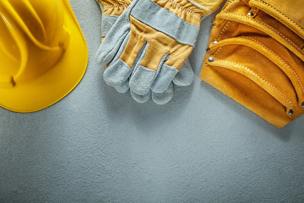 Tool belt safety gloves hard hat on concrete background