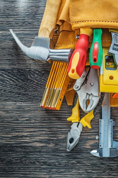 Herramientas de construcción de correa de herramientas de cuero sobre fondo de madera — Foto de Stock