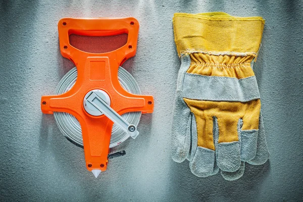 Beschermende handschoenen lintmeter op concrete achtergrond — Stockfoto