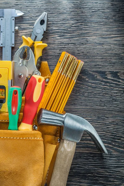 Leather tool belt building tooling on wooden board vertical view — Stock Photo, Image