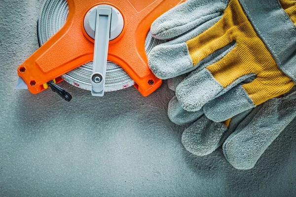 Guantes de seguridad cinta métrica sobre fondo de hormigón —  Fotos de Stock