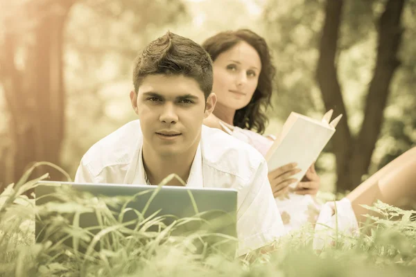 A young couple relaxing in park on green grass — Stock Photo, Image