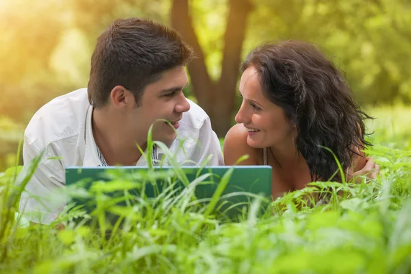 Enamorados joven pareja en hierba en parque —  Fotos de Stock