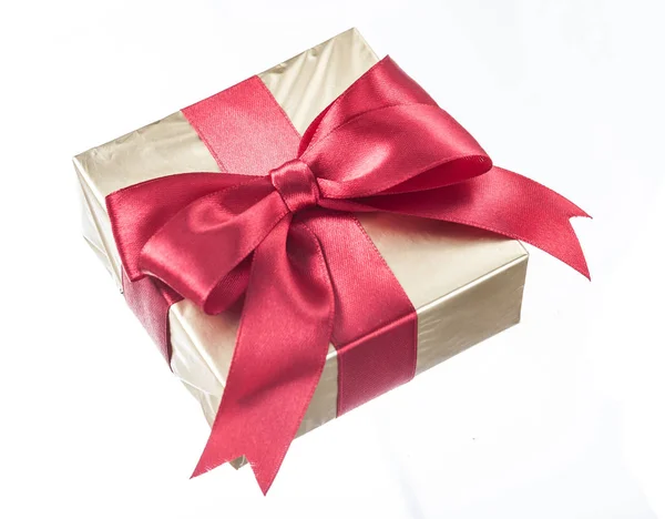 礼品包裹在闪闪发光的纸与红色弓孤立的白色 — 图库照片