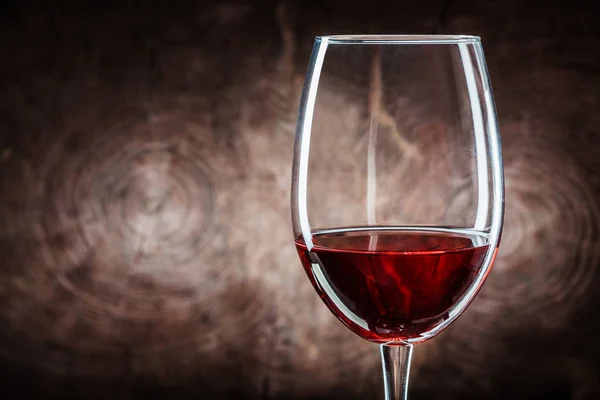 Bicchiere da vino molto da vicino con vino rosso su fondo legno — Foto Stock