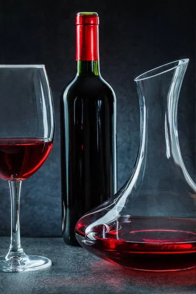Decanter wineglass and bottle with red wine on black background — 스톡 사진