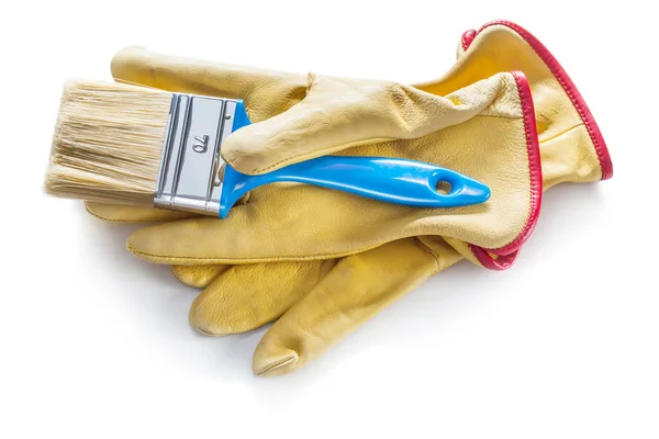 Pincel azul sobre guantes de trabajo de cuero amarillo aislados —  Fotos de Stock