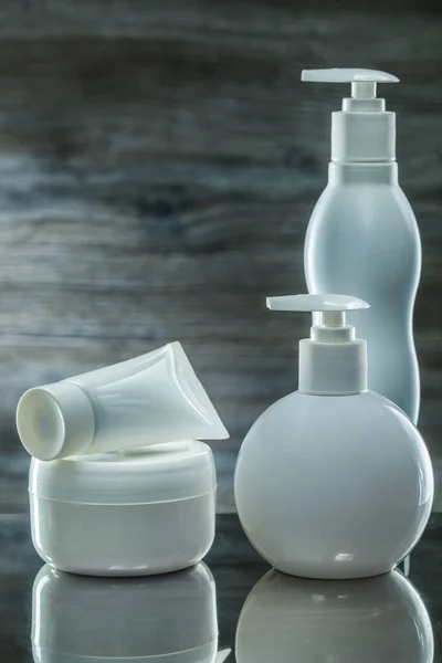 Skincare items white sprayers and tube on dark background — Stock Photo, Image