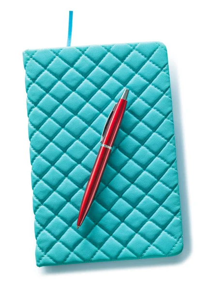 青い革のノートパッドと赤いボールペンが白い部分に隔離されています — ストック写真