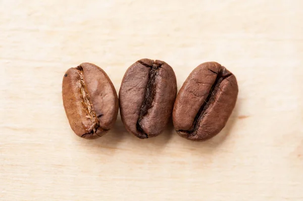 Макро из кофейных зерен на деревянном фоне — стоковое фото