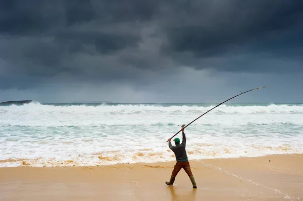 Fisherman fishing on beach — Stock Photo, Image