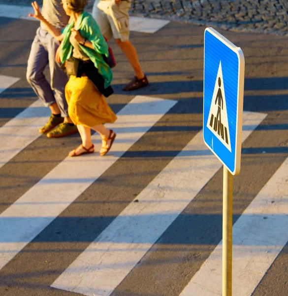 Crosswalk sign. People on background — Stock Photo, Image