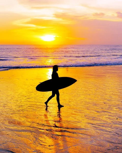 冲浪者在日落时带着冲浪板走在沙滩上 巴厘岛 — 图库照片